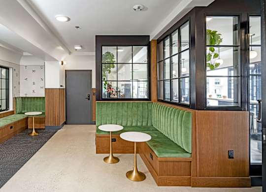 A room with a green couch and a wooden door.