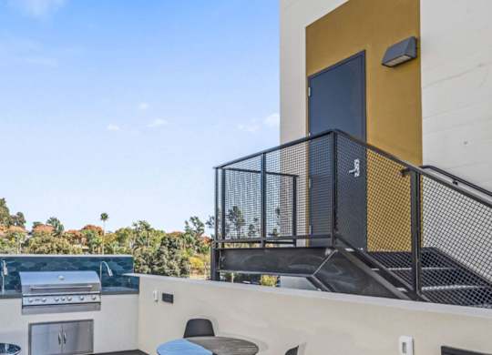 A balcony with a black railing and a yellow wall.