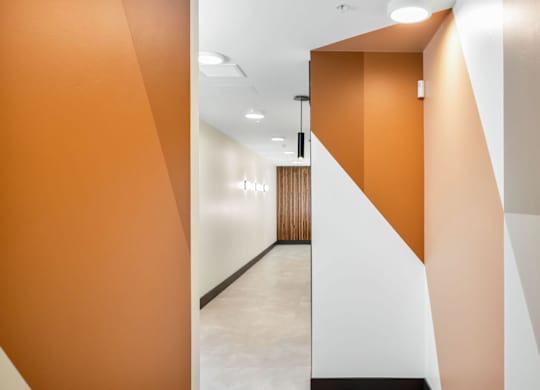 A hallway with orange walls and a white door.