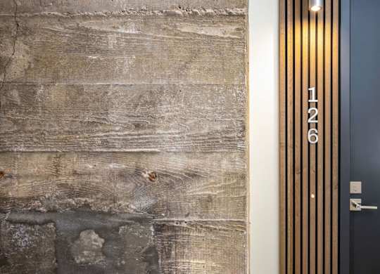 A black door with a gold numbered plate on it.