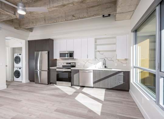 A modern kitchen with a washer and dryer built in.