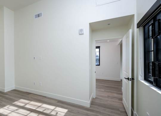 A room with a white wall and a door on the right.
