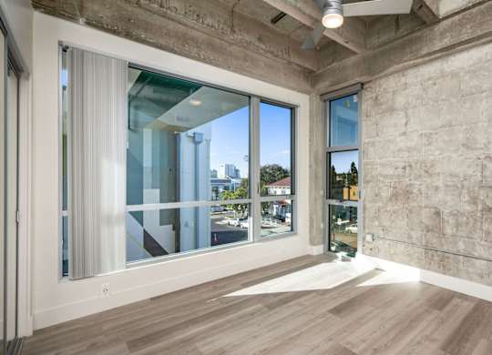 A room with a large window and a wooden floor.