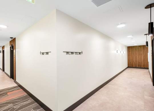 A long hallway with a sign that says "EXIT" on the wall.