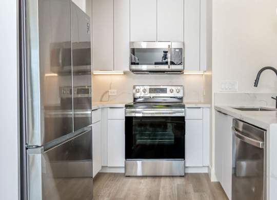 A modern kitchen with stainless steel appliances and white cabinets.