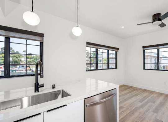 A modern kitchen with a stainless steel dishwasher and a white countertop.