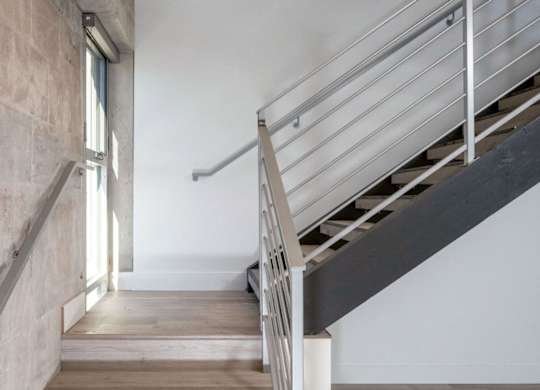 A staircase with a metal railing and wooden steps.