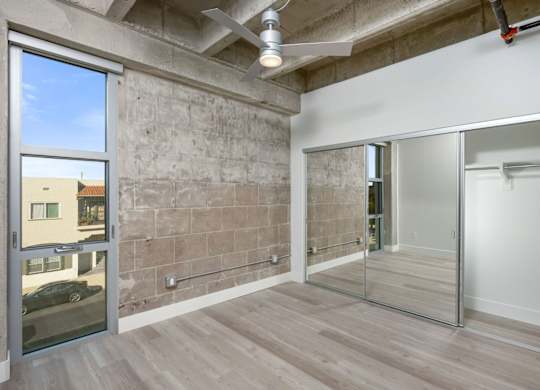 A room with a concrete wall and a glass door leading outside.