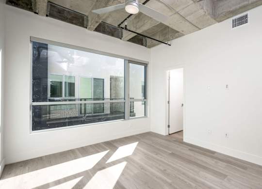 A room with a large window and a wooden floor.