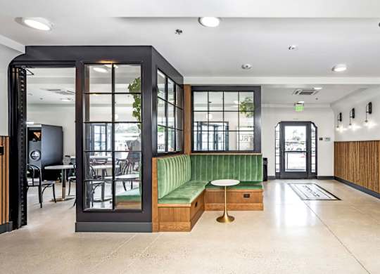 A modern interior with a green bench and a wooden floor.