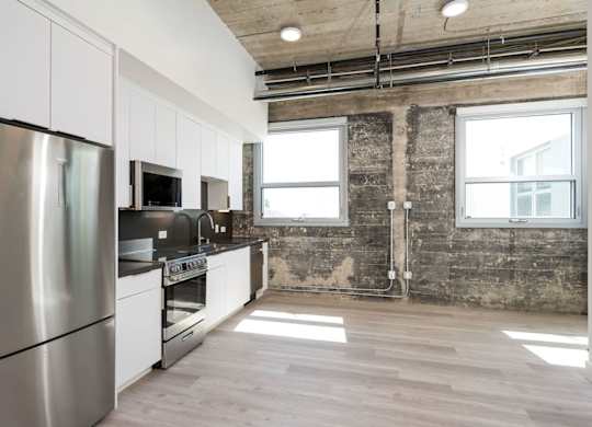 A kitchen with stainless steel appliances and wooden floors.