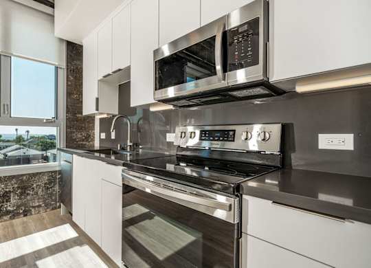A modern kitchen with stainless steel appliances and white cabinets.