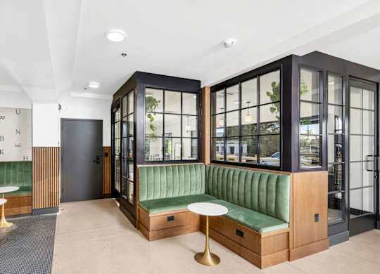 A room with a green sofa and a white table.