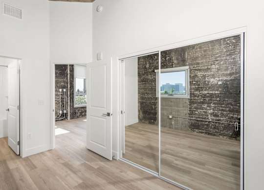 A room with a white door and a glass wall with a view of a city.