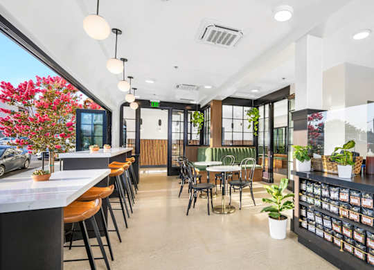 A modern cafe with a counter and chairs.
