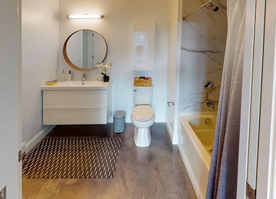 A bathroom with a toilet, sink, and mirror.