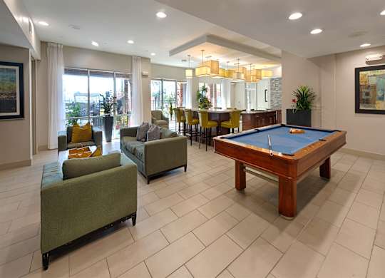 A large room with a pool table and a green couch.