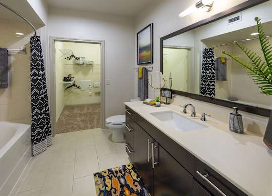 A bathroom with a white sink and a mirror above it.