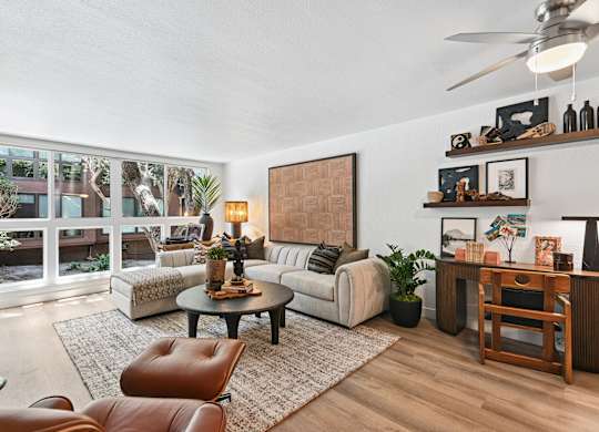 A living room with a brown leather chair and a white couch.