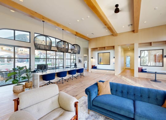 a living room with blue couches and chairs and large windows at The Villas at Anacapa Canyon, Camarillo, CA