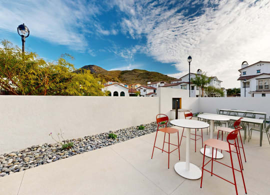 a patio with tables and chairs on a balcony at The Villas at Anacapa Canyon, Camarillo