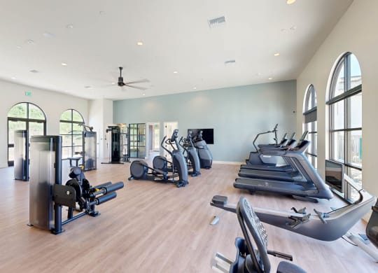 a gym with cardio machines and weights on a wooden floor at The Villas at Anacapa Canyon, Camarillo, 93012