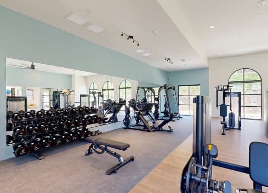 a gym with cardio equipment and weights in a building with windows at The Villas at Anacapa Canyon, Camarillo, California