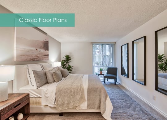 a master bedroom with a large bed and a window at The Meadows Apartments, Culver City , CA
