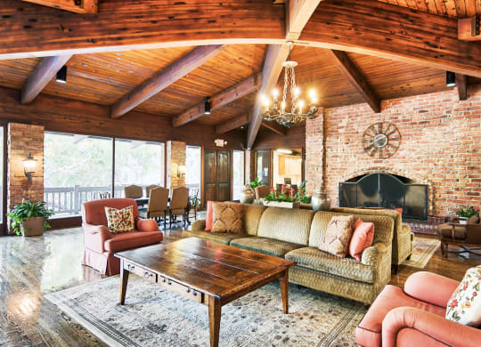 a living room with furniture and a brick fireplace at The Meadows Apartments, Culver City