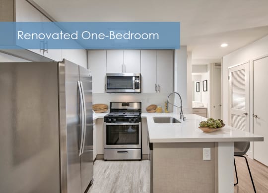 an updated one bedroom kitchen with stainless steel appliances and white cabinets at The Meadows Apartments, Culver City , CA
