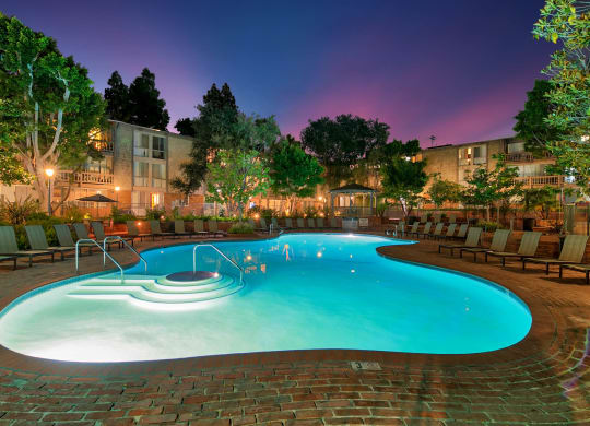 a swimming pool at night at an apartment complex with a resort style pool at The Meadows Apartments, Culver City , 90230