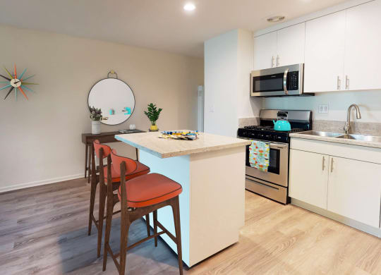 a kitchen with an island and a counter top with three chairs  at Rancho Los Feliz, Los Angeles, CA, 90039