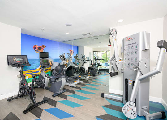 a gym with various cardio machines and a water fountain at Sendero Huntington Beach, Huntington Beach
