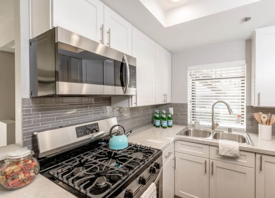A kitchen with a gourmet stove and a sink at Sendero Huntington Beach, Huntington Beach California
