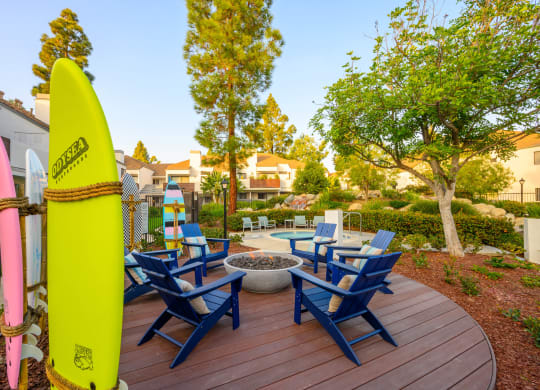 a patio with a surfboard and chairs on a deck at Sendero Huntington Beach, Huntington Beach, CA 92647