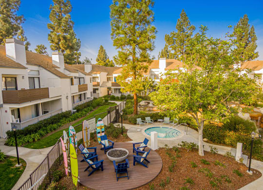 a courtyard with a pool and patio with chairs and trees at Sendero Huntington Beach, California, 92647
