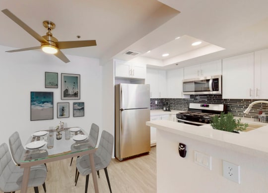 a kitchen and dining room with stainless steel appliances and a ceiling fan at Sendero Huntington Beach, Huntington Beach, CA 92647