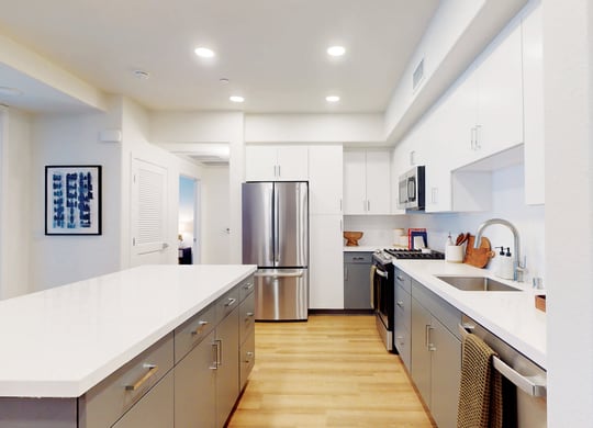 a large kitchen with stainless steel appliances and white counter tops at The Villas at Anacapa Canyon, Camarillo