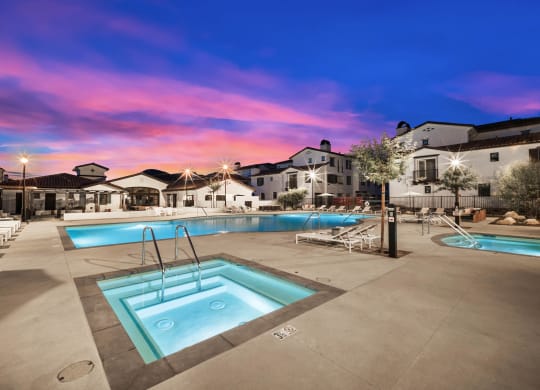 a swimming pool at dusk with apartments in the background at The Villas at Anacapa Canyon, Camarillo