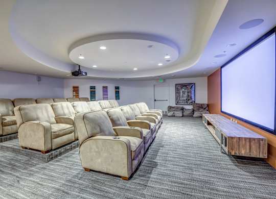 A movie theater with rows of seats and a large screen. at Esprit Apartments, California