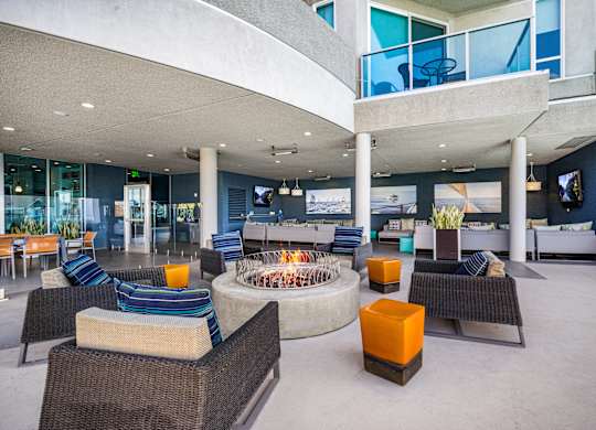 A modern outdoor seating area with a fire pit in the center. at Esprit Apartments, California, 90292