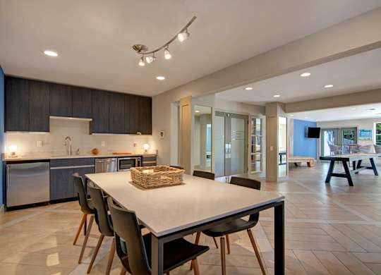 A modern kitchen with a dining table and chairs.