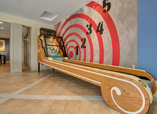 A long wooden bench with numbers on the wall behind it.
