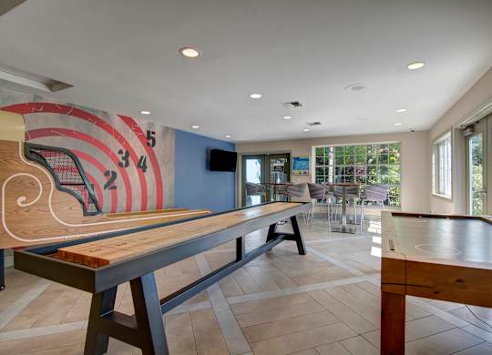 A room with a ping pong table and a TV.
