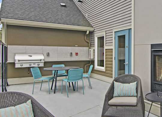 A patio with a table and chairs and a fireplace.
