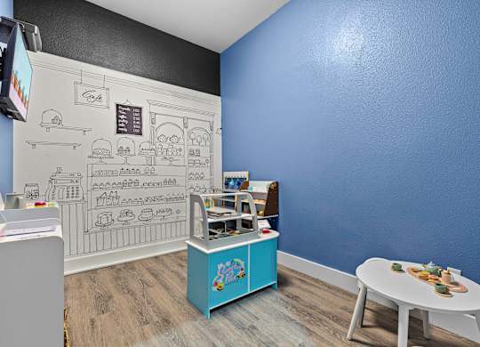 A blue wall with a white table and a counter with a cash register.