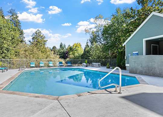 A swimming pool surrounded by trees and a building.