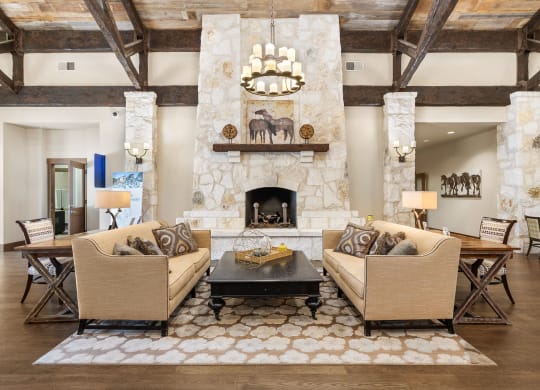 living room with couches and a table and a fireplace at Lakeline East Apartments, Texas