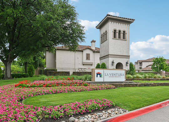 A white building with a tower and a sign that says