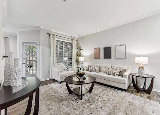 A living room with a white couch, a coffee table, and a rug. at Stone Oak @ Parmer, Austin, Texas